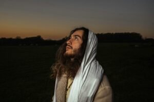 a man with long hair wearing a white blanket