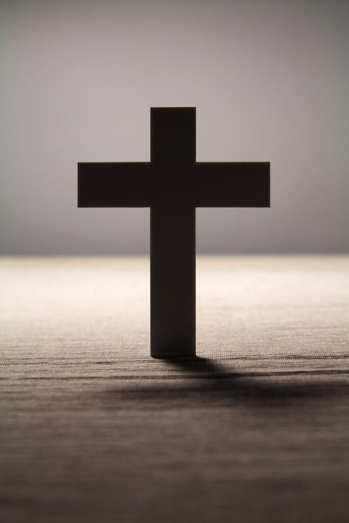a black cross sitting on top of a wooden table
